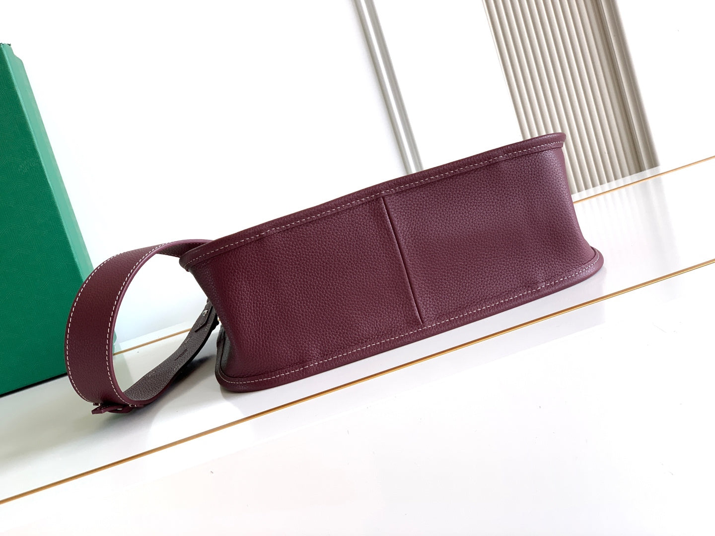 Maroon Goyard bag with pebbled leather exterior and top zipper strip detail