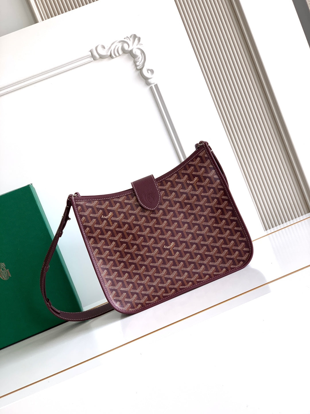 Maroon Goyard shoulder bag with patterned front panel and wrist strap