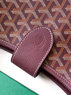 Maroon Goyard bag flap corner with embossed emblem and textured leather
