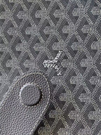 Goyard monogram bag close-up of embossed leather patch, dark gray