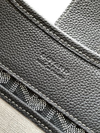 Goyard monogram bag close-up of pebbled leather exterior and seam lines, dark gray