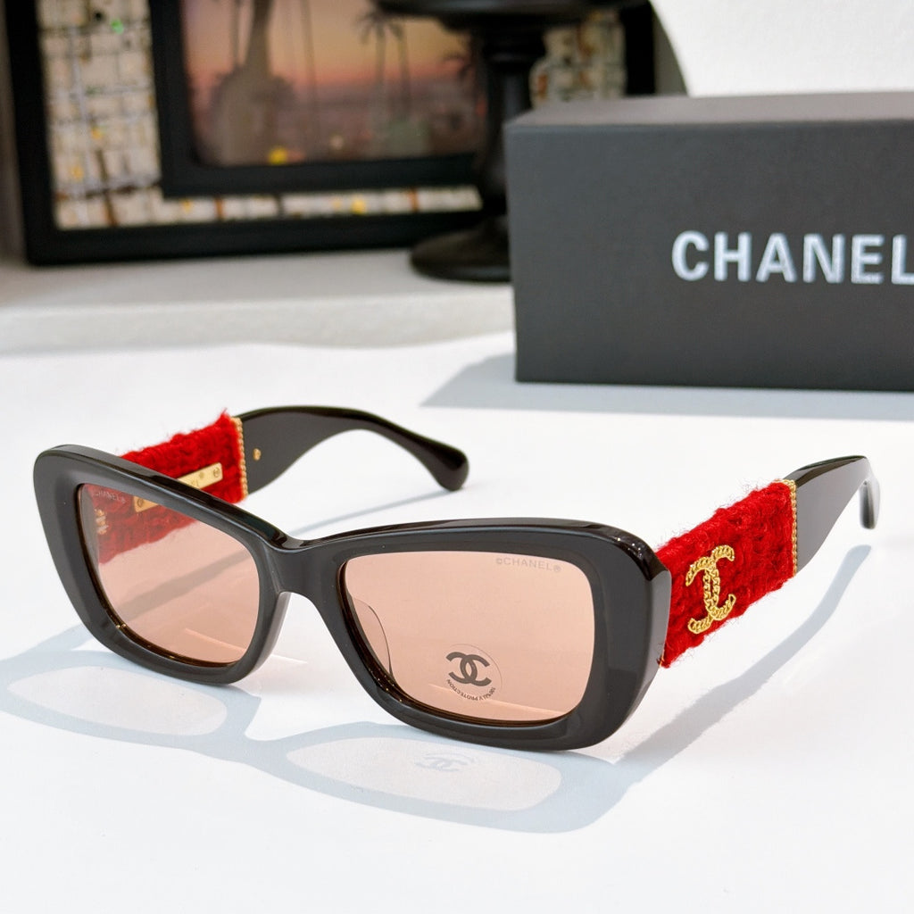 Black sunglasses with red fabric temples and gold logo detail