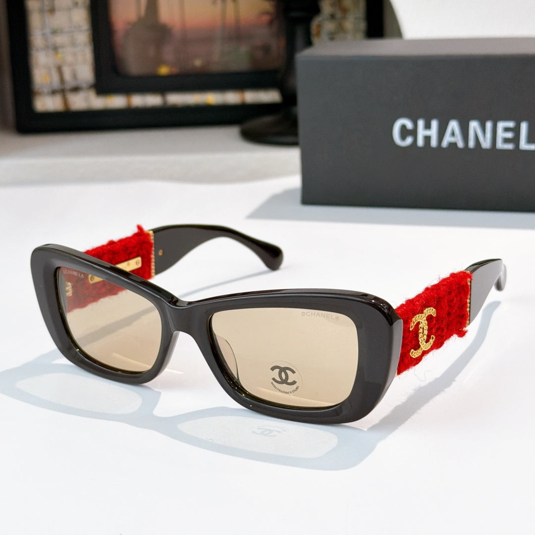 Black sunglasses with red fabric temples and gold logo detail