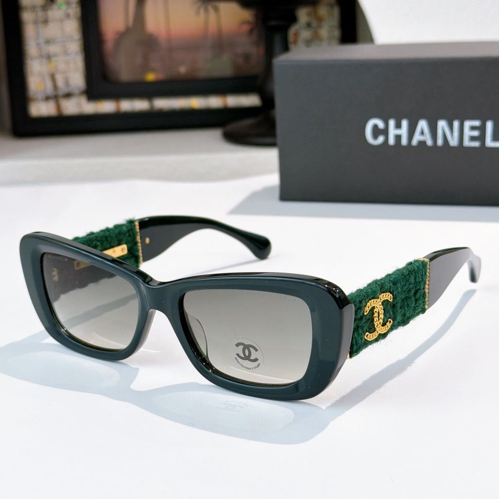 Dark teal sunglasses with green fabric temples and gold logo detail