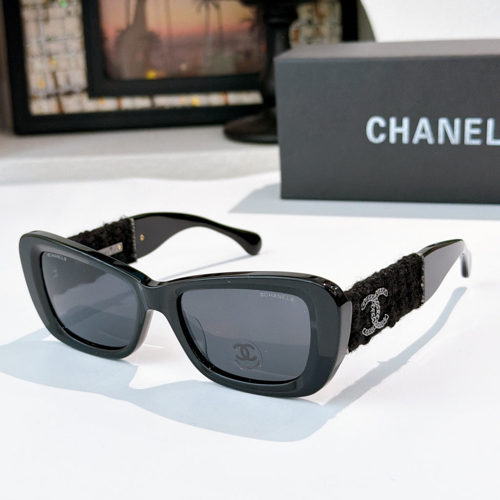 Dark gray sunglasses with black fabric temples and gold logo detail