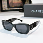 Dark gray sunglasses with black fabric temples and gold logo detail
