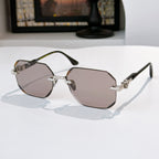 Hexagon sunglasses with silver frame, gold details, and light mauve tinted lenses