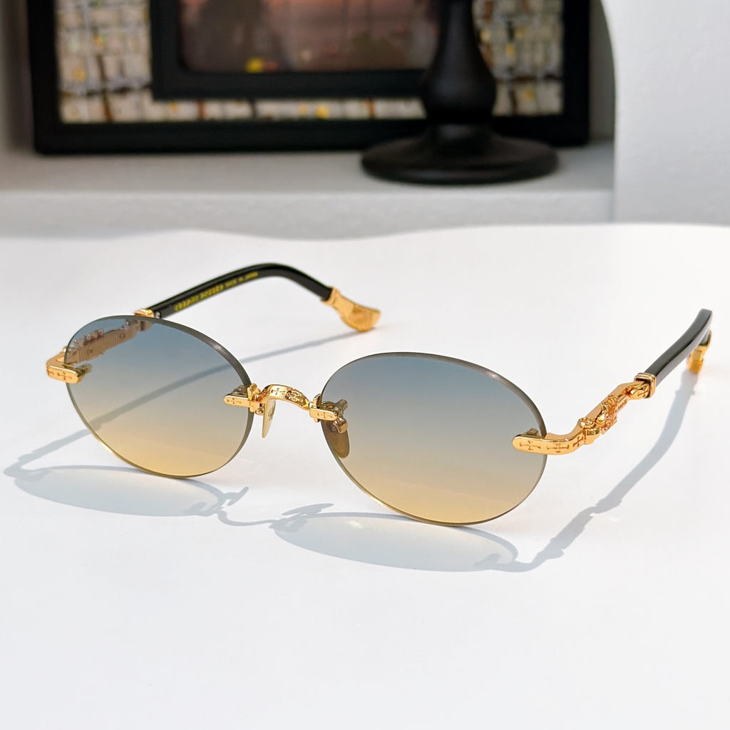 Round chrome glasses with amber lenses and gold-toned decorative temple details