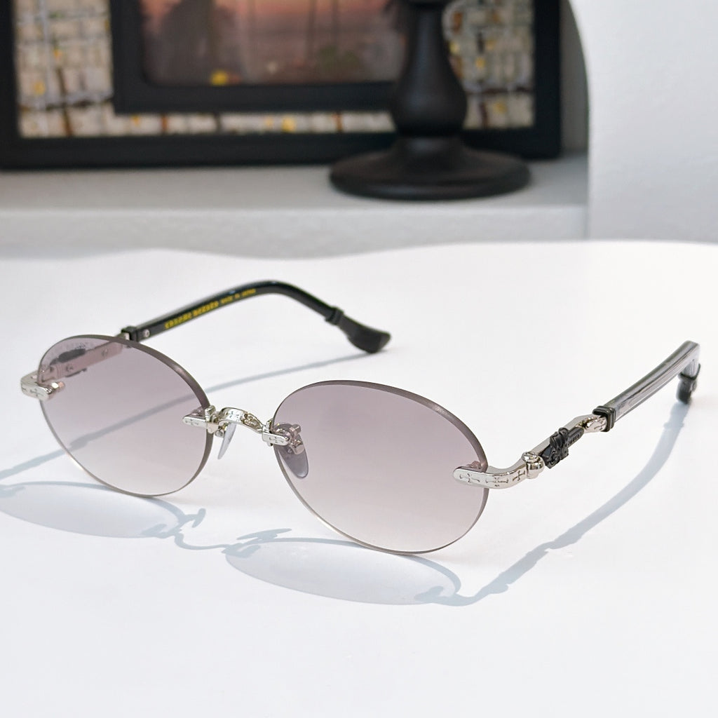 Round chrome glasses with rose-tinted lenses and black-and-silver temple details