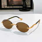 Round chrome glasses with dark brown lenses and gold-toned decorative temples