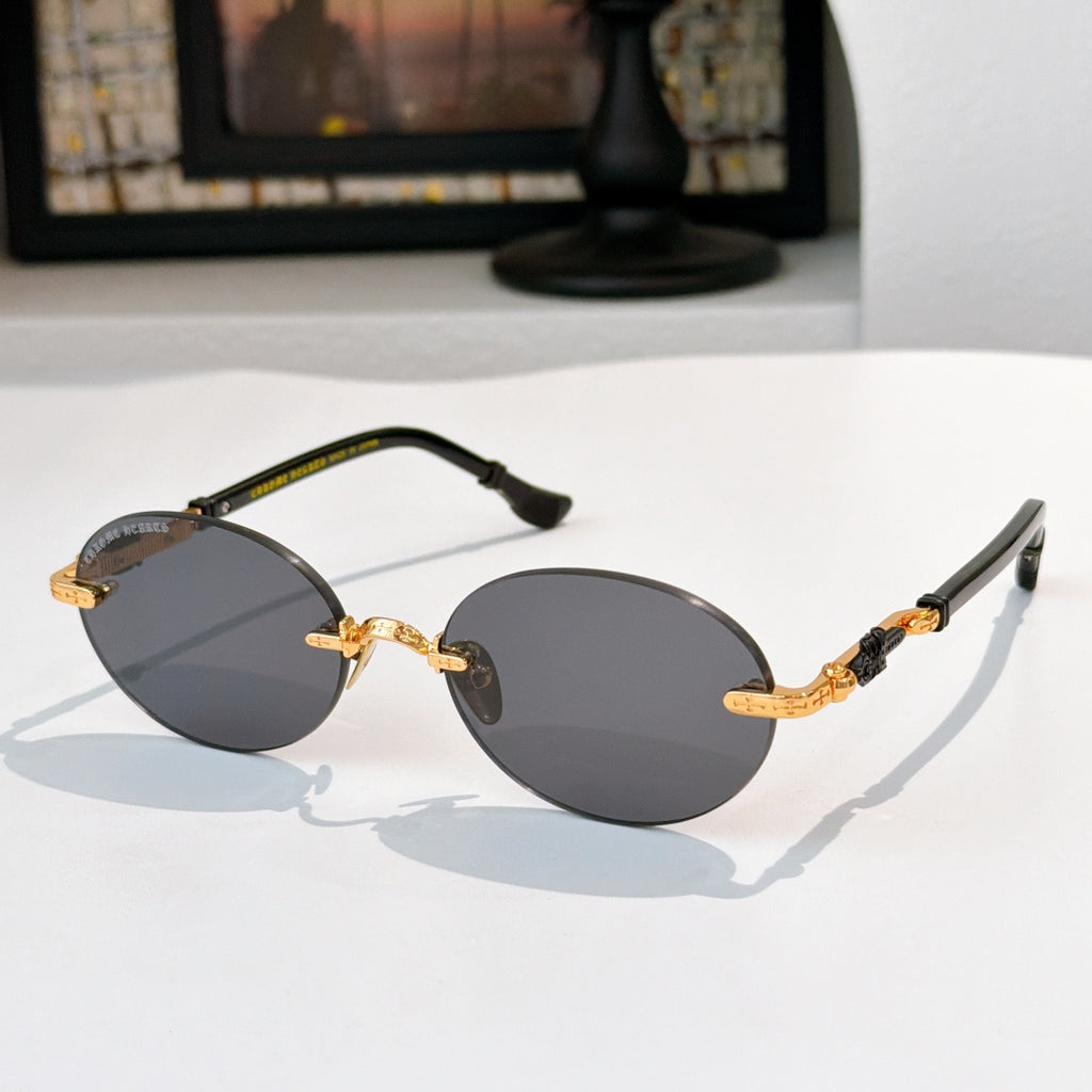 Round chrome glasses with dark lenses, gold accents, and black temple tips