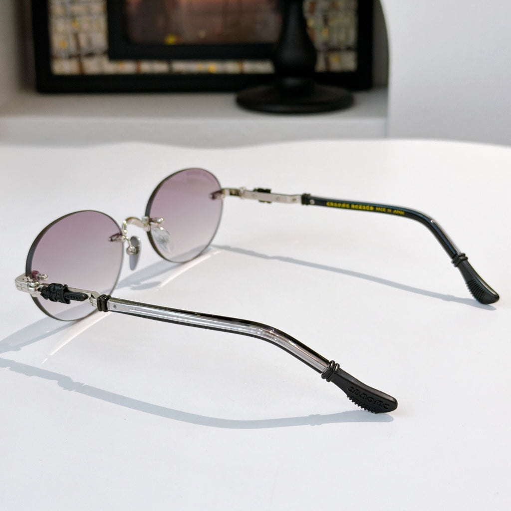 Round chrome glasses with pale pink lenses, side view, and black temple tips