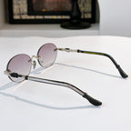 Round chrome glasses with pale pink lenses, side view, and black temple tips