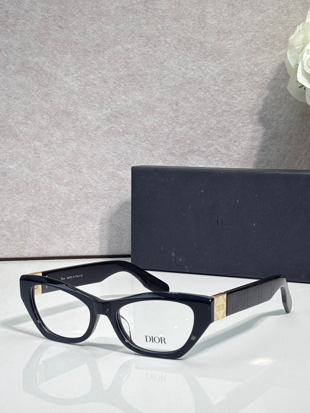 Dior eyeglass frames with matte black front, curved arms, clear lenses