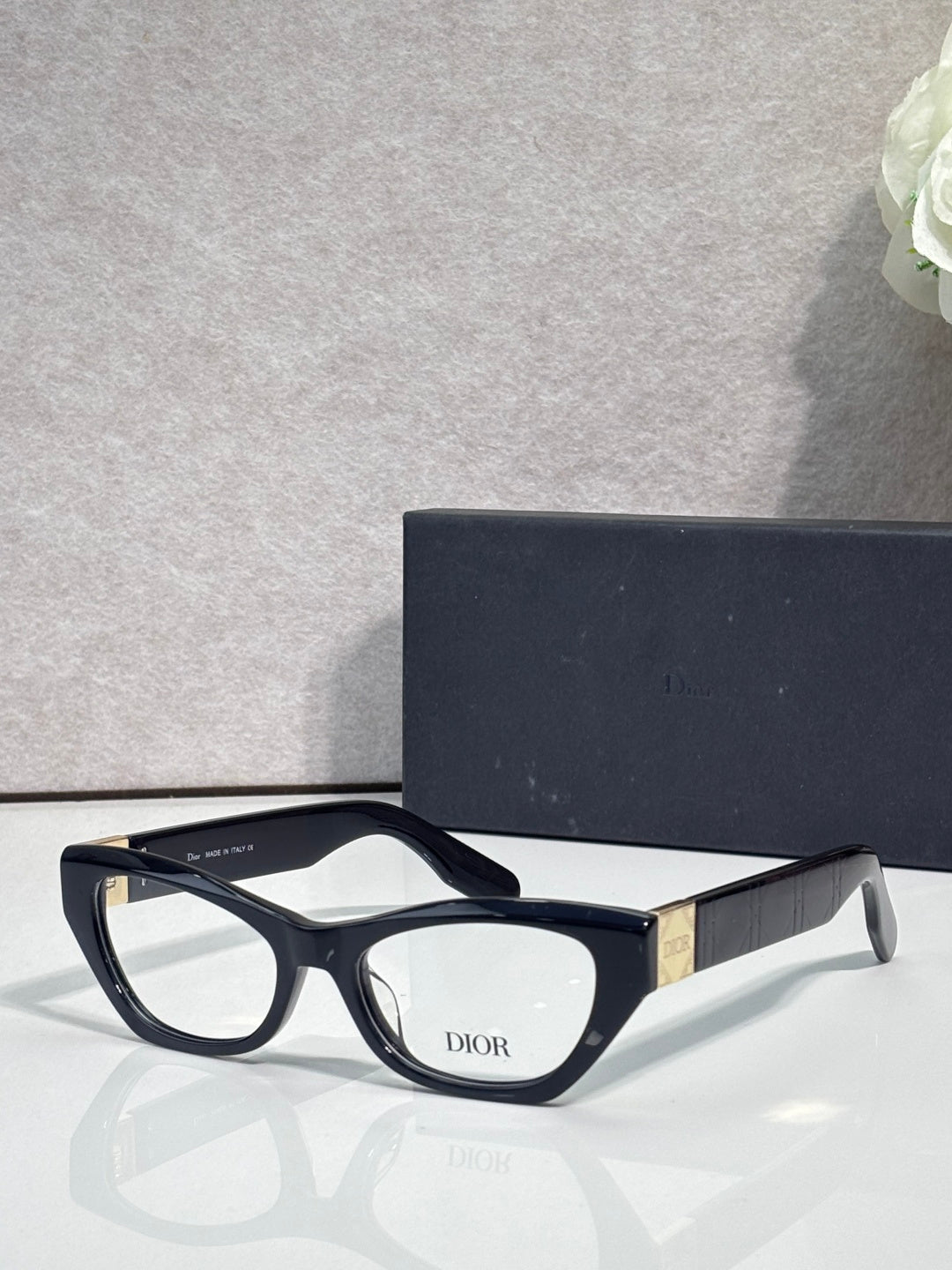 Dior eyeglass frames with matte black front, curved arms, clear lenses