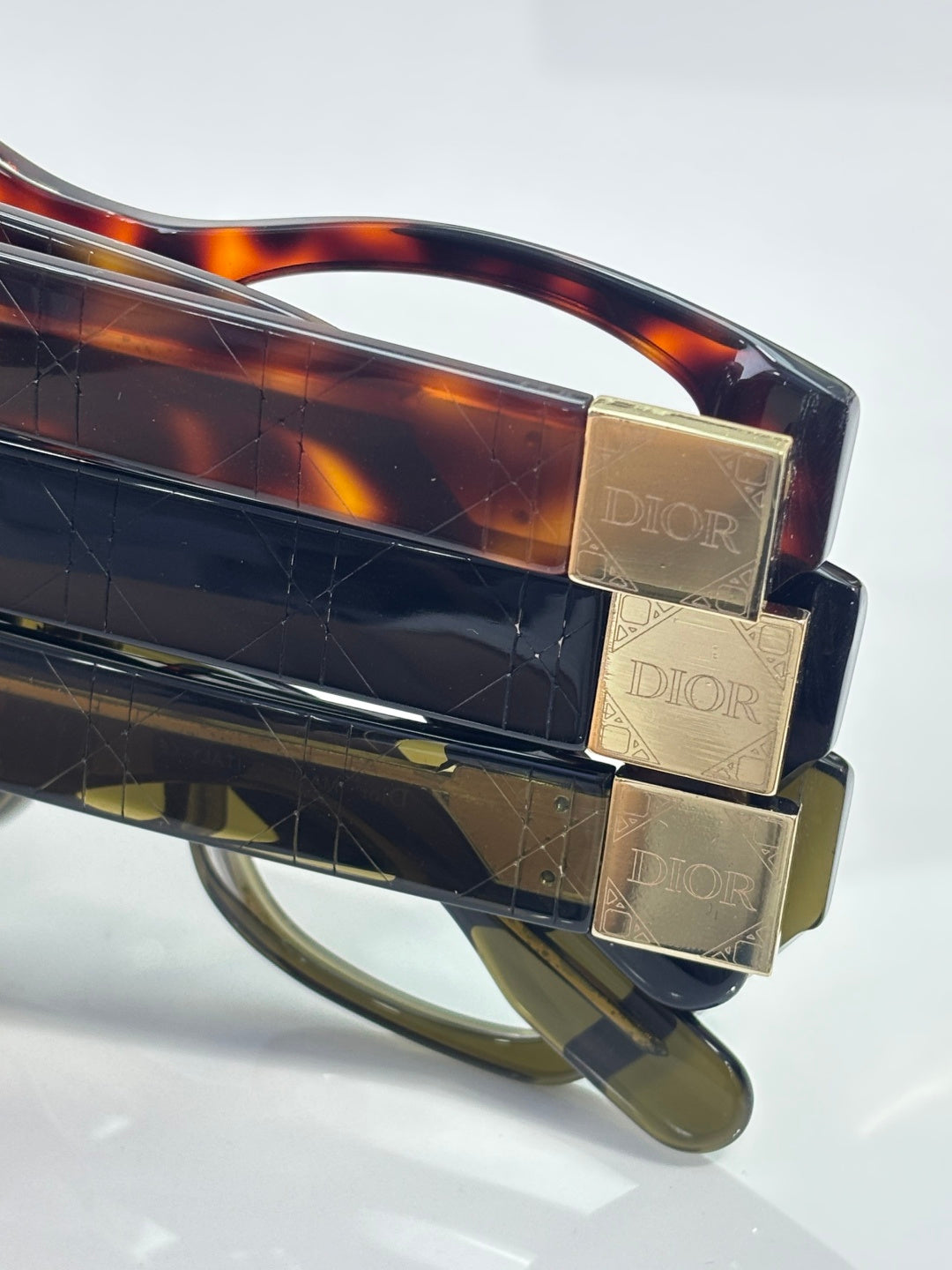 Dior eyeglass frame temple detail with tortoise acetate and gold Dior plates