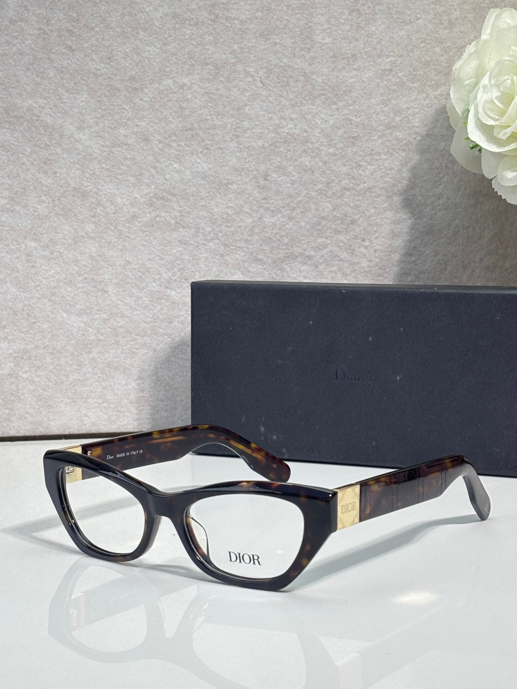 Dior eyeglass frames with black acetate front and tortoise temples, clear lenses