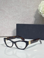 Dior eyeglass frames with black acetate front and tortoise temples, clear lenses