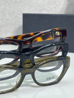 Dior eyeglass frames close-up: black and olive fronts with gold and tortoise temple details