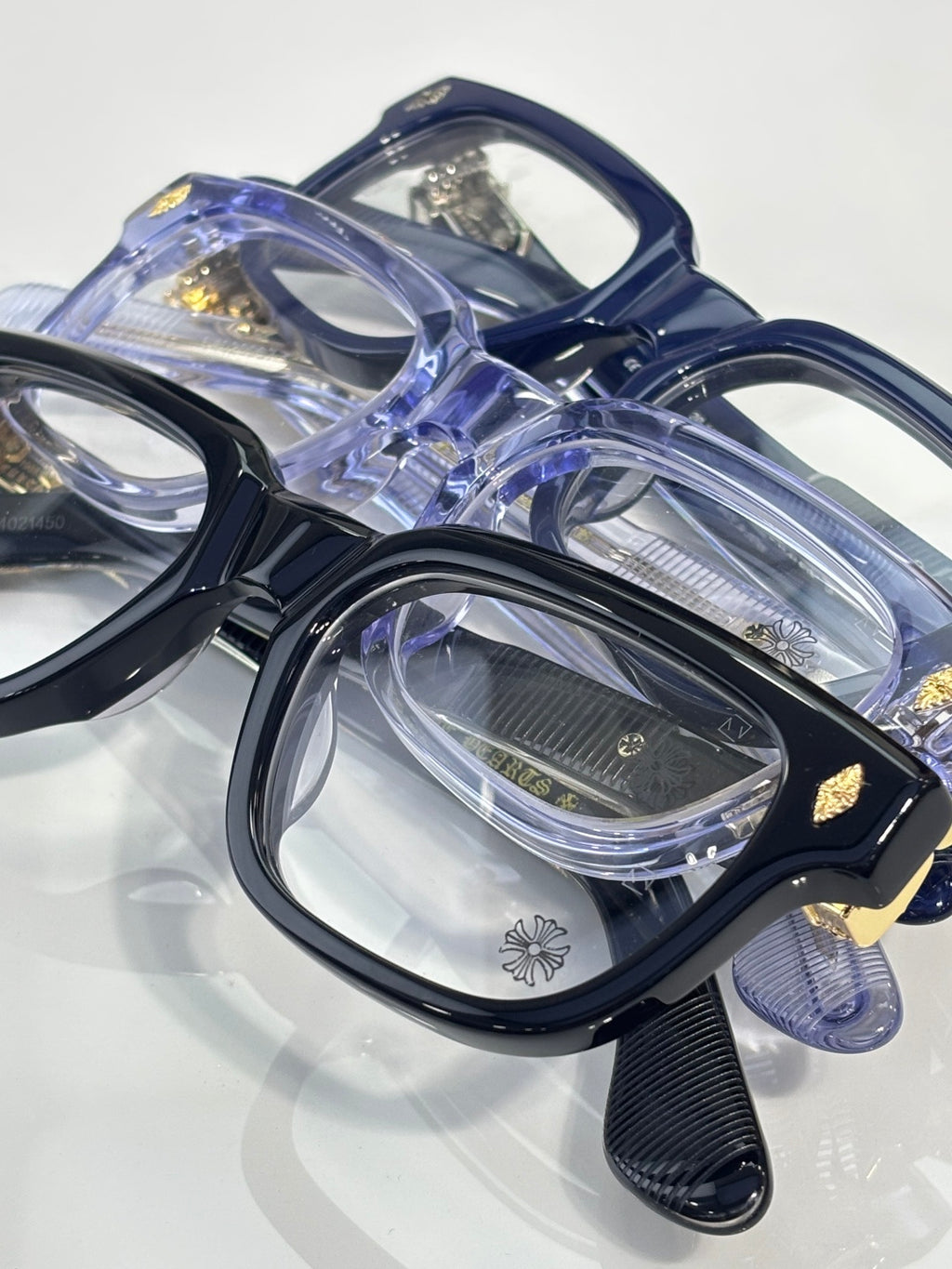 Chrome glasses close-up with blue frames, clear lenses, stacked view