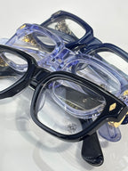 Chrome glasses close-up with blue frames, clear lenses, stacked view