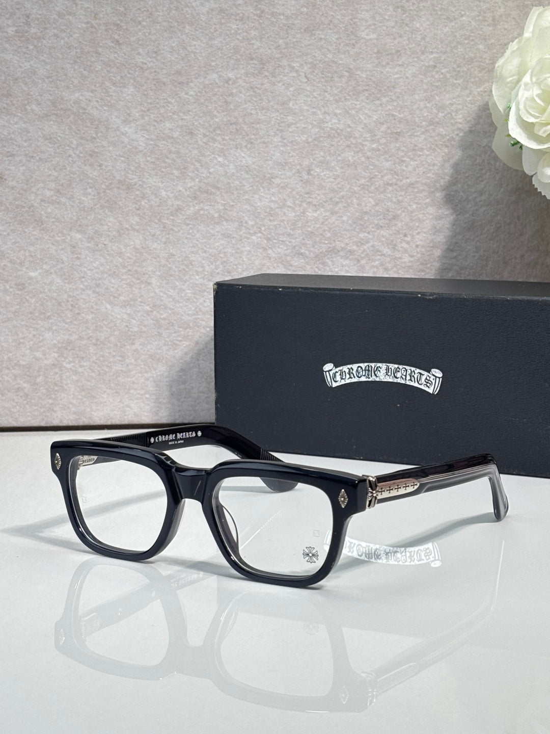 Chrome glasses with dark blue frames and clear lenses, gold temple tips