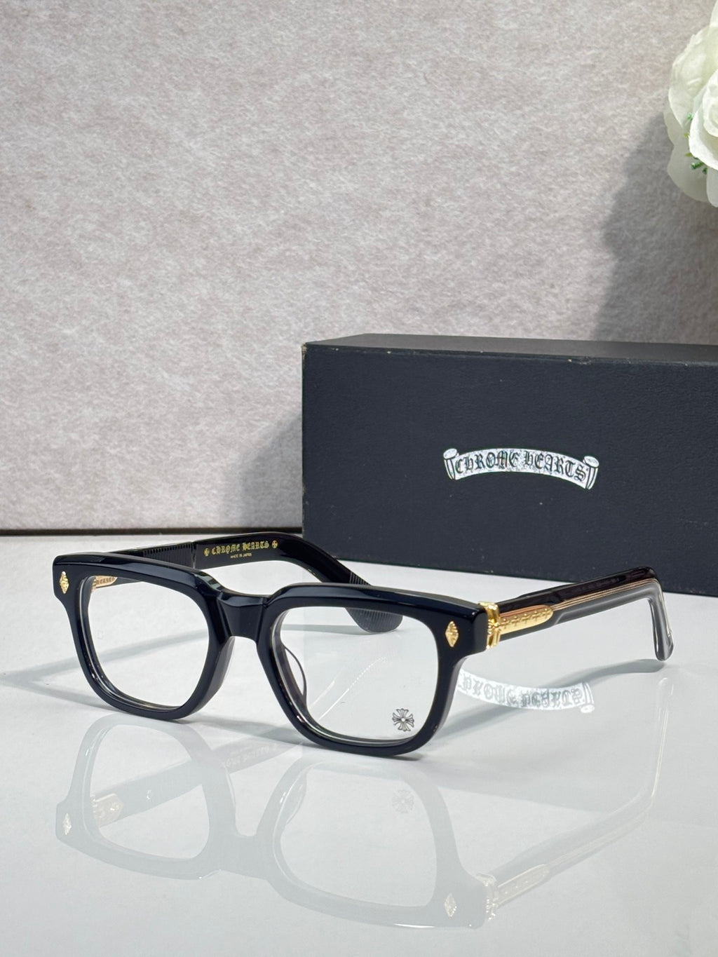 Chrome glasses with dark frames and clear lenses, gold temple accents