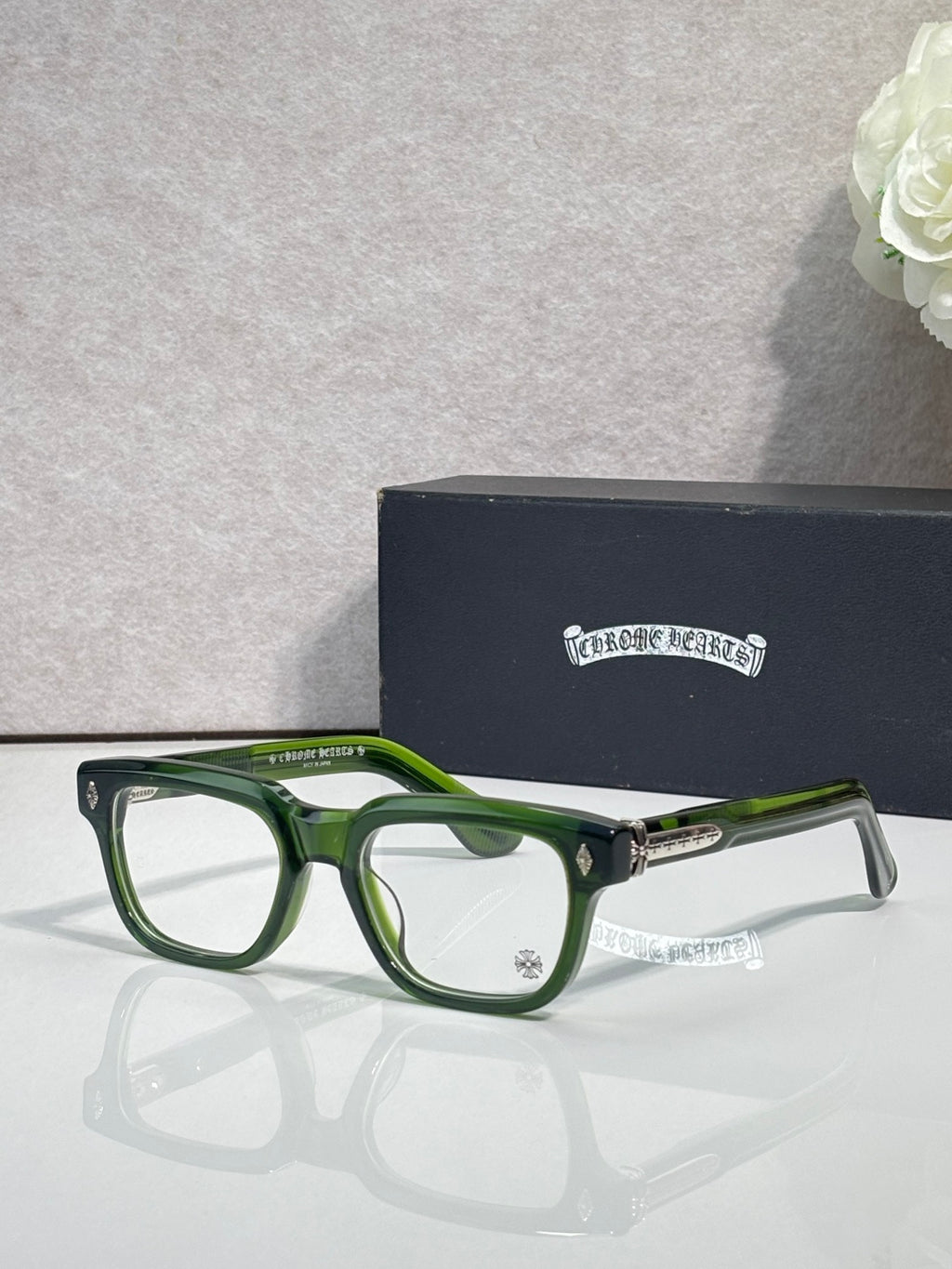 Chrome glasses with green frames and clear lenses, gold hinge detail