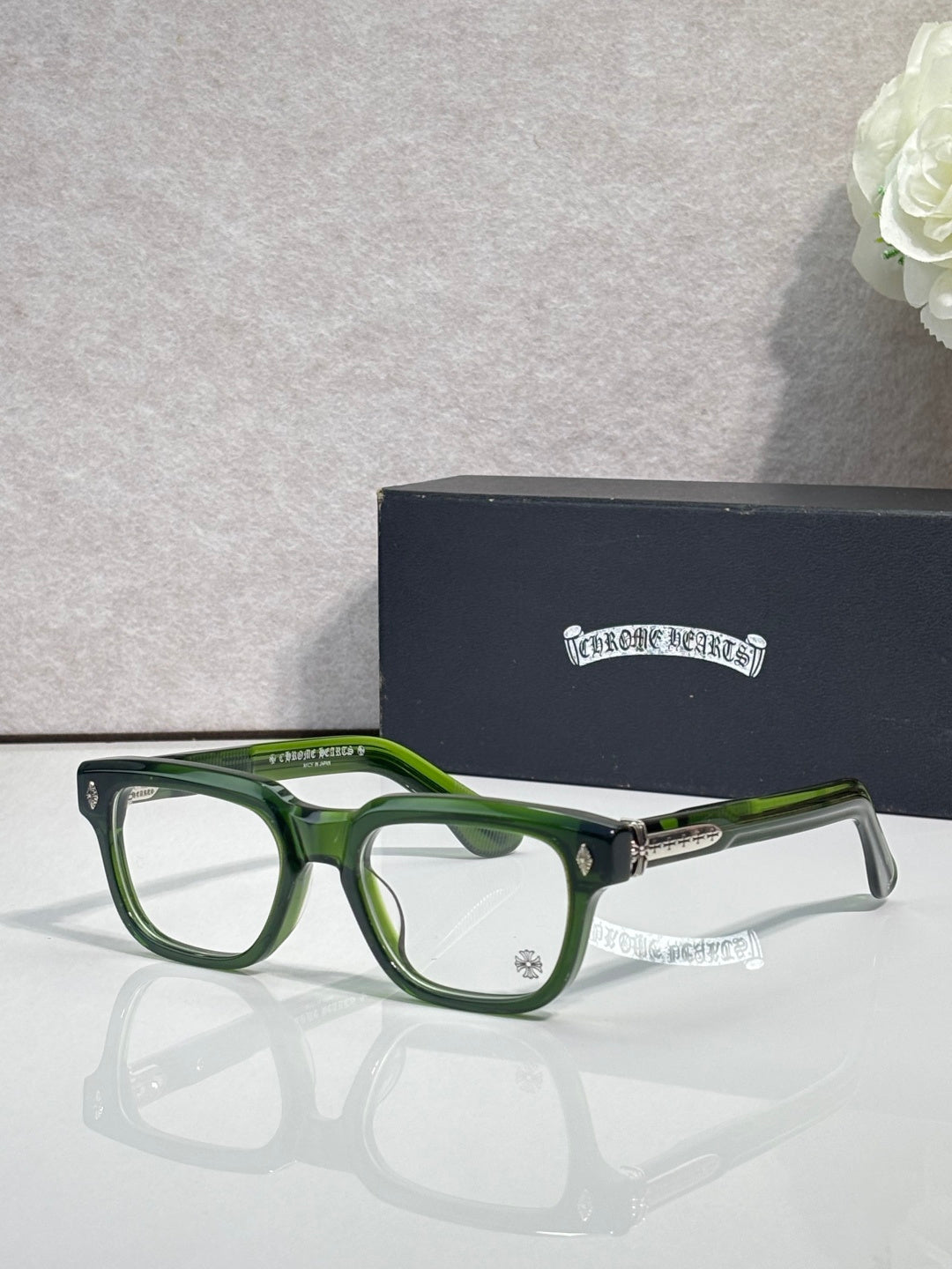 Chrome glasses with green frames and clear lenses, gold hinge detail