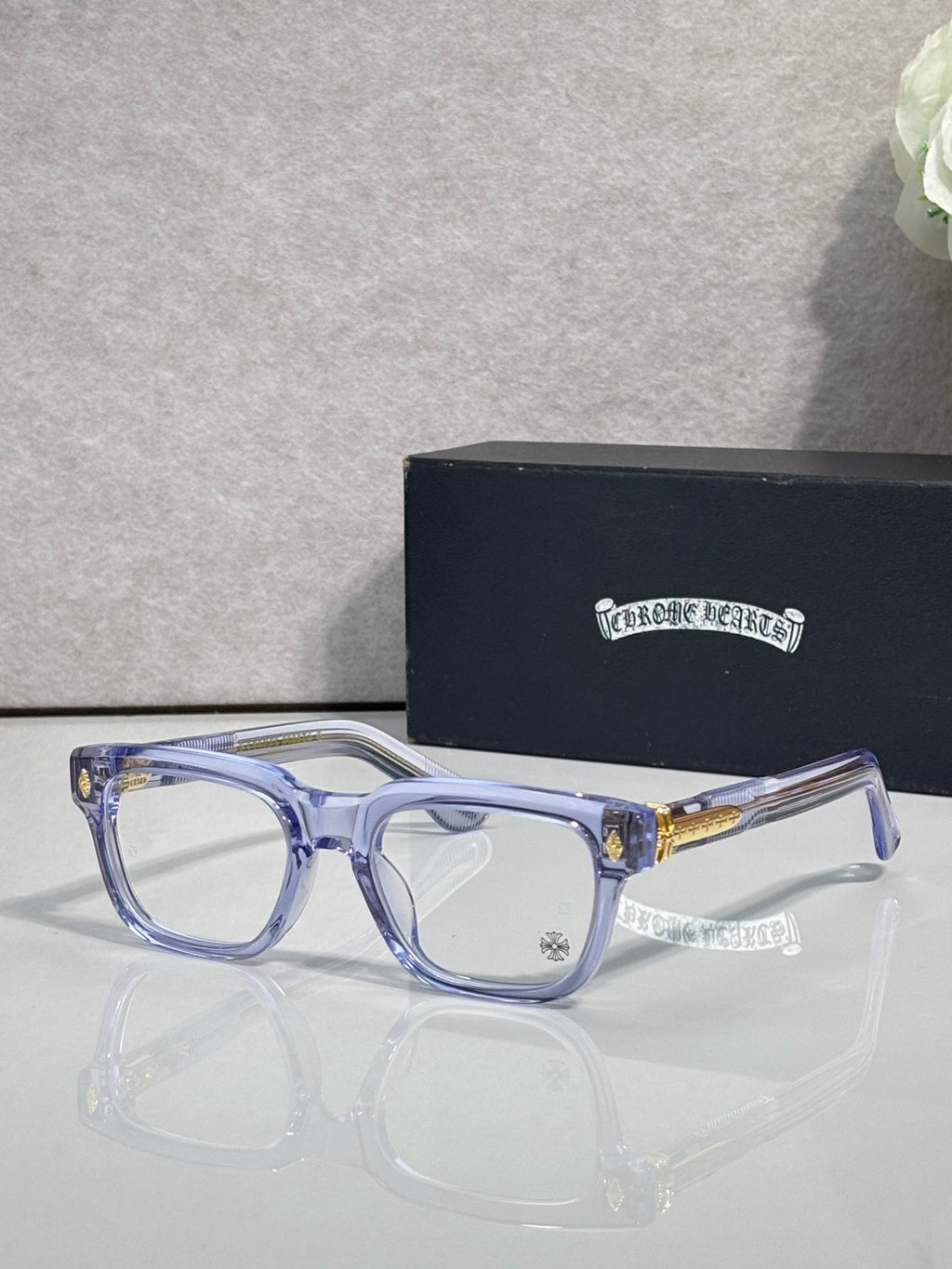 Chrome glasses with light blue frames and clear lenses, slim gold temple detail