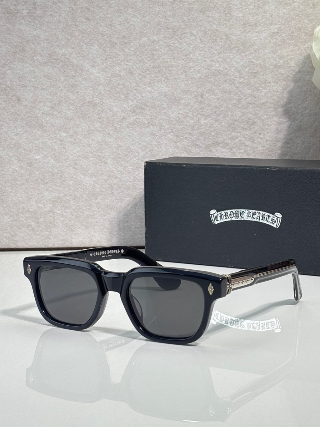Black sunglasses with dark lenses and clear temple tips, front view