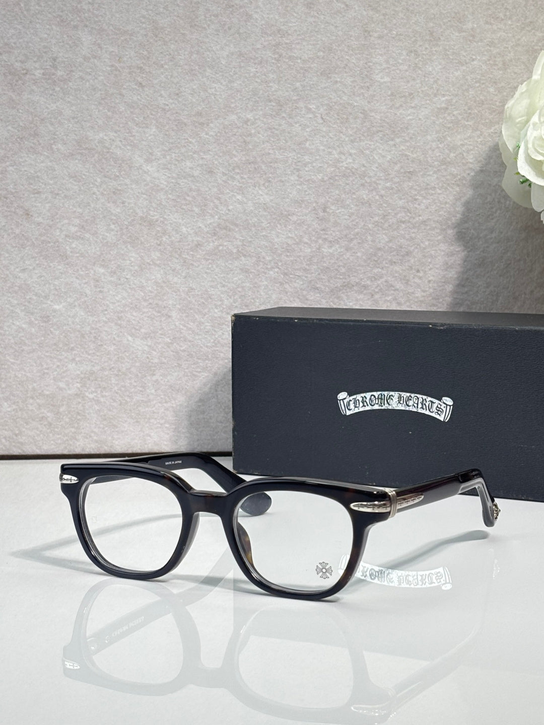 Black round eyeglasses with clear lenses and gold-toned hinges