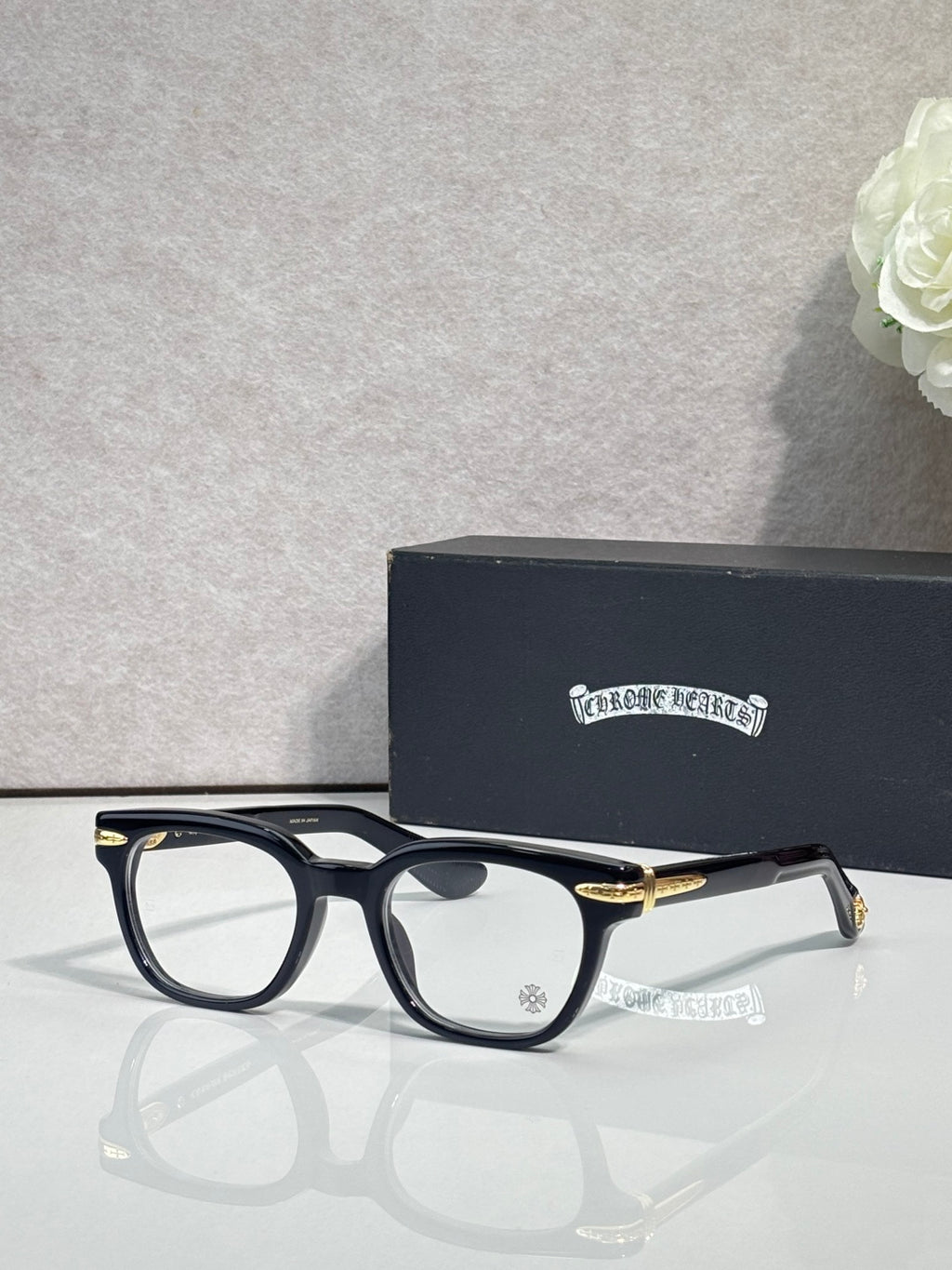 Black round eyeglasses with gold-toned temple accents and clear lenses