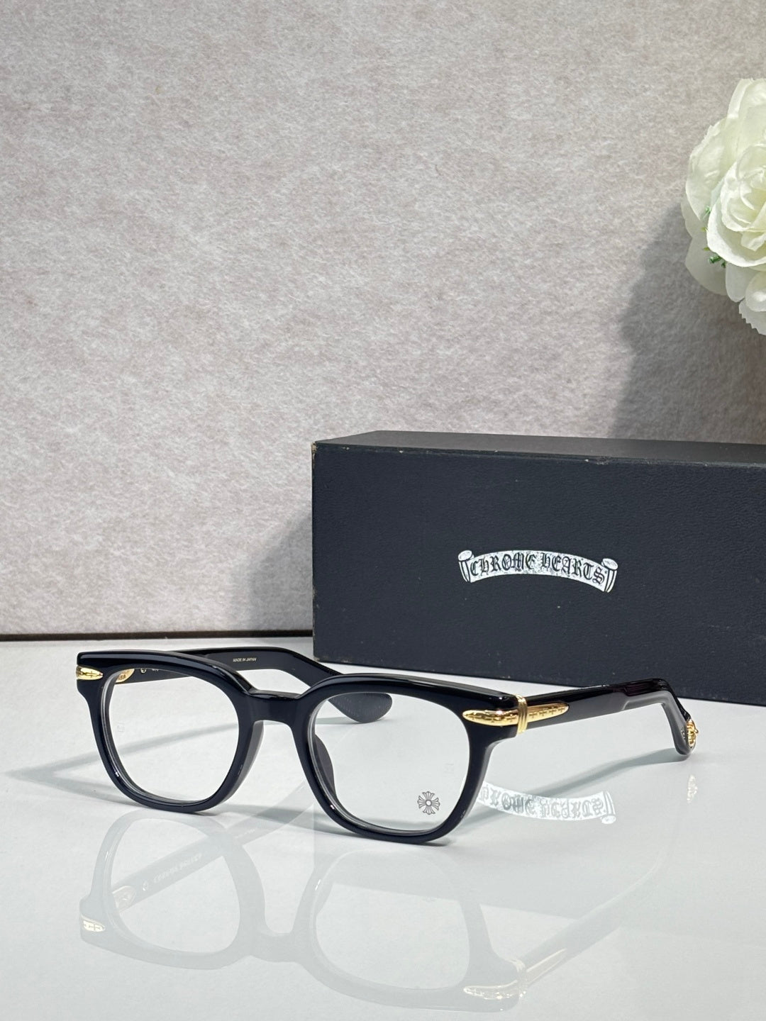 Black round eyeglasses with gold-toned temple accents and clear lenses