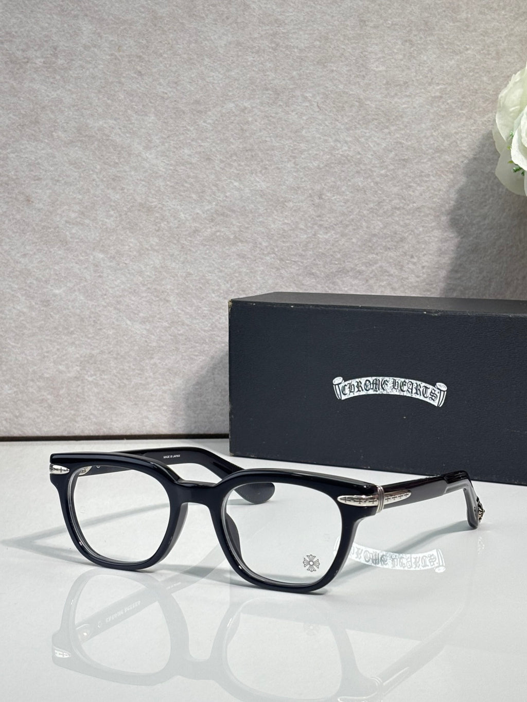 Black round eyeglasses with clear lenses and gold-toned temple tips