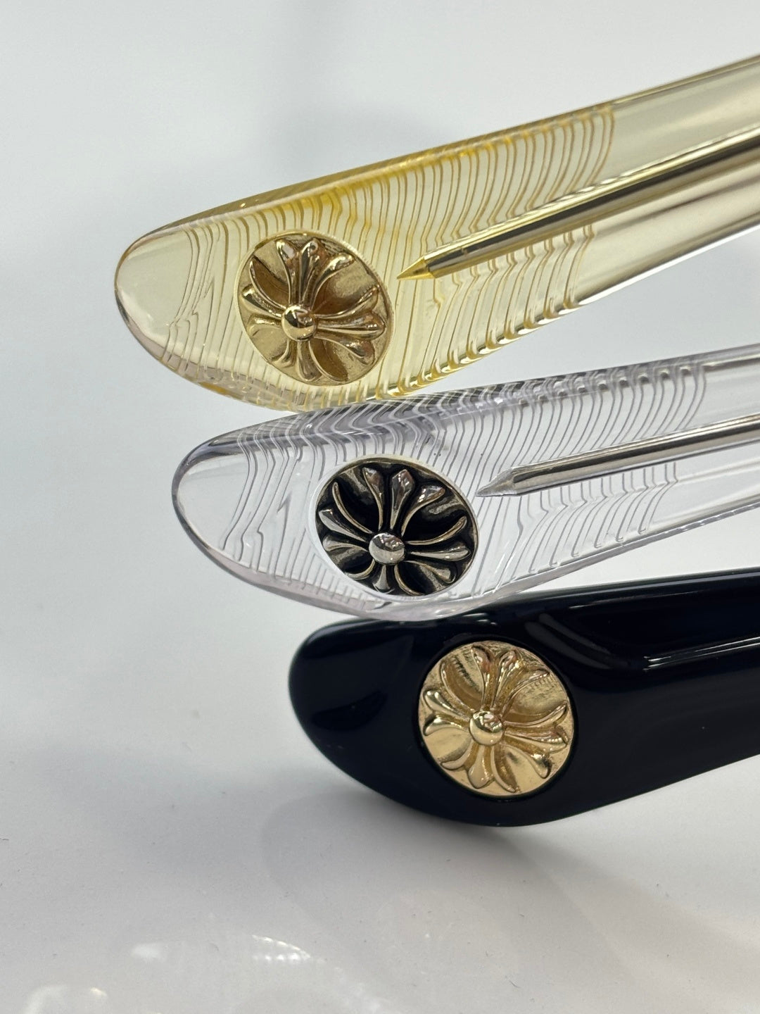 Gold and silver eyeglasses temple tips with engraved floral details
