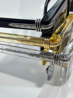 Glasses close-up: engraved metal temple arms with clear and gold-tone detailing.