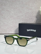 Glasses with dark green frames and green-tinted lenses, with gold-tone accents.