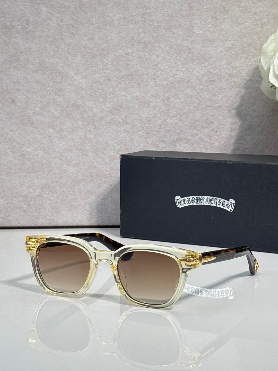 Glasses with gold frames and light brown lenses, with clear ear tips.