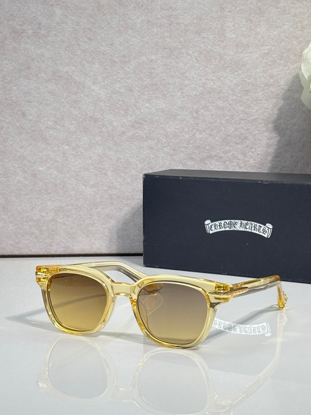 Glasses with yellow-gold frames and light brown lenses, with clear ear tips.