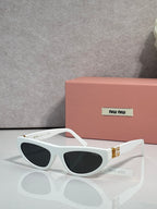 White cat-eye sunglasses with dark lenses and gold logo detail at temples.