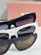Close-up of white sunglasses with dark lenses and black temple details.