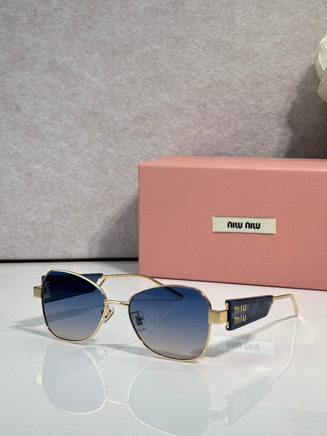 Round sunglasses with blue-tinted lenses and gold-tone metal frames