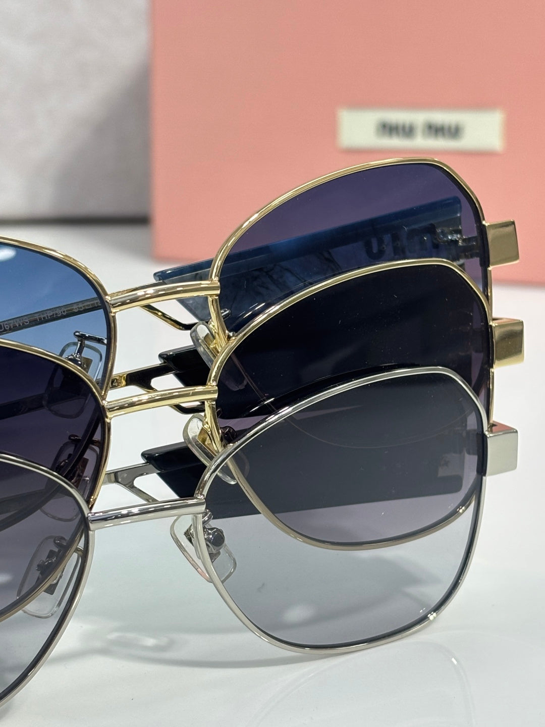 Round sunglasses with navy lenses and gold-tone metal frames