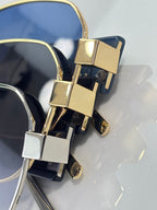 Gold-tone sunglasses hinge detail with dark blue lenses