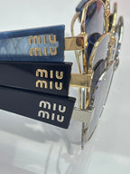 Gold-tone sunglasses frames with dark lenses and logo hardware