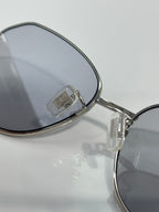 Metal sunglasses arm with Miu Miu logo and dark lens