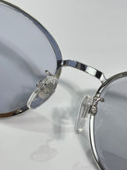 Silver sunglasses close-up of lens, metal bridge, and hinge detail