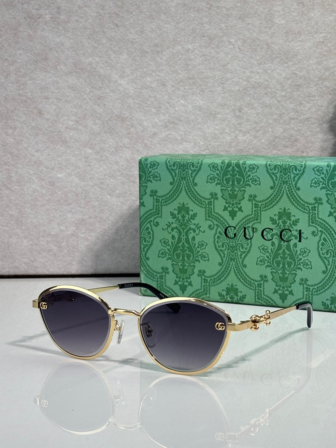 Gold metal sunglasses with dark blue lenses and chain-link temple details