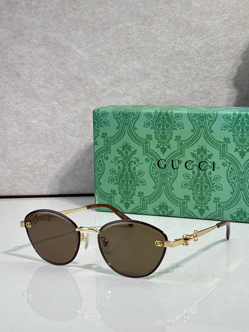 Gold metal sunglasses with dark brown lenses and chain-link temple details